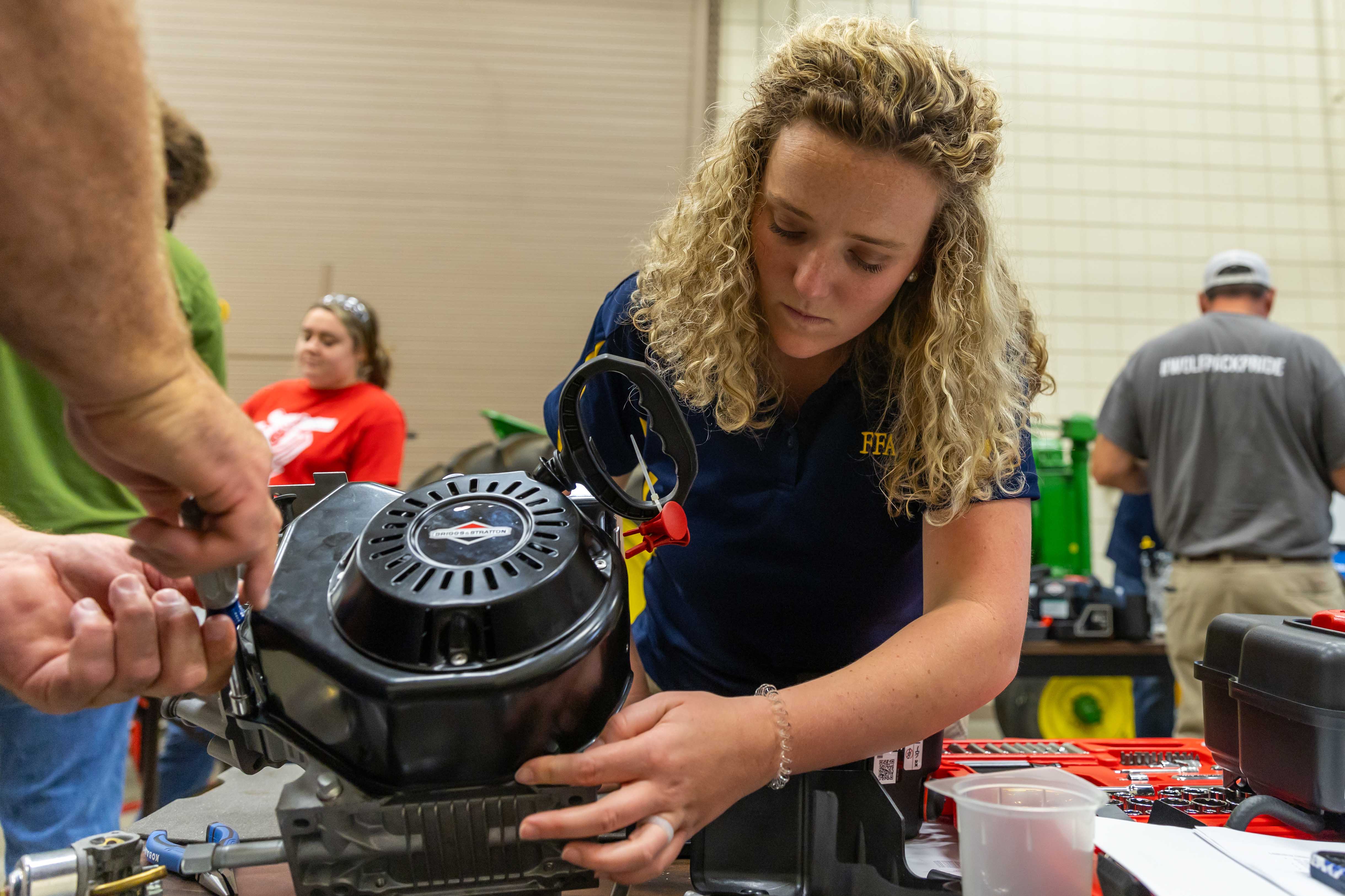 Student working on a small gas engine in a lab