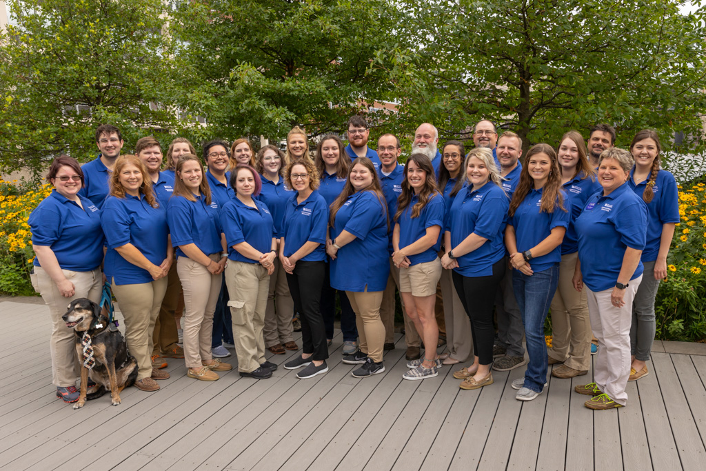 CASE attendees group photograph all dressed in wildcat blue shirts in the deck, garden area outside of the Garrigus Building