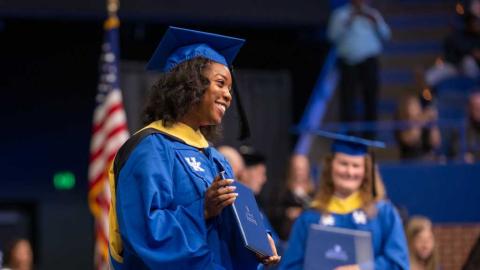 A student holds her diploma at commencement